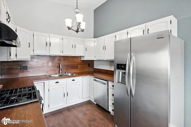 18723 N Lowrie Loop, Eagle River, AK 99577 - kitchen featuring appliances with stainless steel finishes, under cabinet range hood, a chandelier, white cabinets, and decorative backsplash