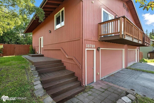 18723 N Lowrie Loop, Eagle River, AK 99577 - view of property exterior featuring an attached garage, asphalt driveway, and a balcony