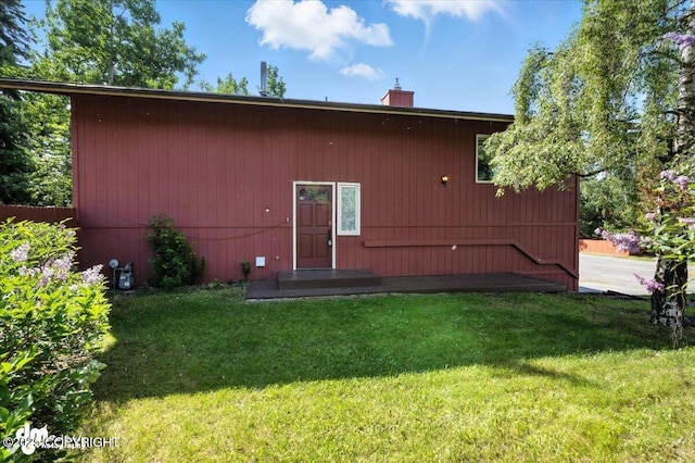 18723 N Lowrie Loop, Eagle River, AK 99577 - back of house featuring a lawn and a chimney