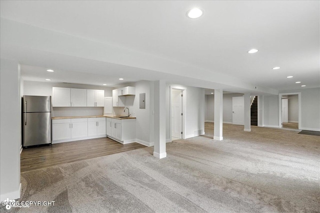 12220 Shiloh Rd, Anchorage, AK 99516 - kitchen featuring freestanding refrigerator, light carpet, open floor plan, white cabinets, and recessed lighting