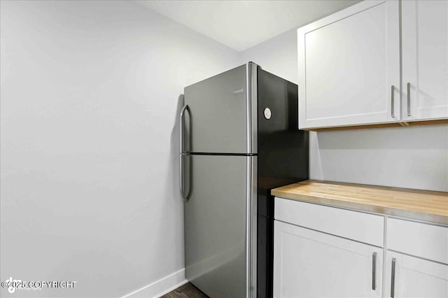 12220 Shiloh Rd, Anchorage, AK 99516 - kitchen with freestanding refrigerator, wooden counters, and white cabinetry