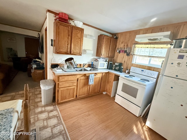 24220 Sterling Hwy, Ninilchik, AK 99639 - kitchen featuring white appliances, light countertops, brown cabinets, light wood-style flooring, and wooden walls