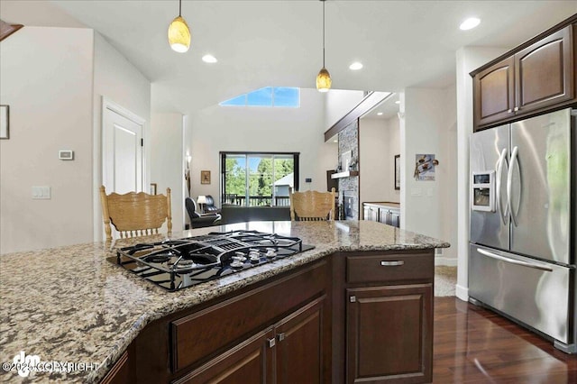 1677 Circlewood Dr, Anchorage, AK 99516 - kitchen featuring stainless steel fridge, black gas stovetop, dark wood finished floors, light stone counters, and dark brown cabinetry