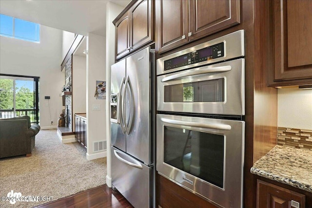 1677 Circlewood Dr, Anchorage, AK 99516 - kitchen featuring stainless steel appliances, dark brown cabinetry, light stone countertops, and dark wood-style floors