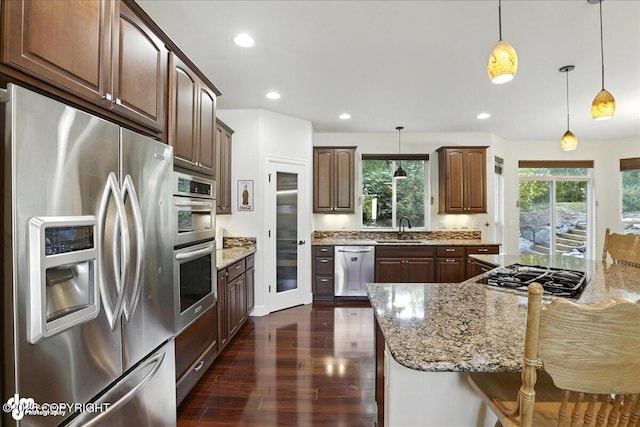 1677 Circlewood Dr, Anchorage, AK 99516 - kitchen with stainless steel appliances, dark wood-style floors, light stone countertops, decorative light fixtures, and recessed lighting