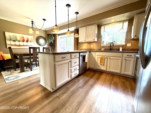 3920 Red Talon Dr, Anchorage, AK 99507 - kitchen featuring stainless steel appliances, ornamental molding, wood finished floors, a peninsula, and decorative light fixtures