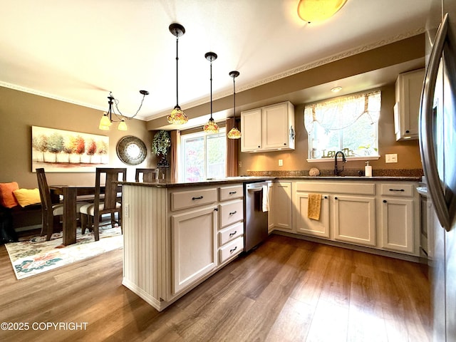 3920 Red Talon Dr, Anchorage, AK 99507 - kitchen with stainless steel appliances, dark wood finished floors, a peninsula, crown molding, and pendant lighting