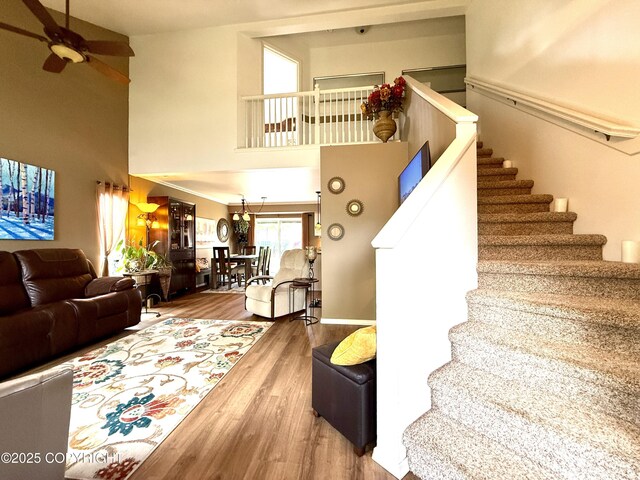 3920 Red Talon Dr, Anchorage, AK 99507 - living room with stairway, wood finished floors, ceiling fan, and a towering ceiling