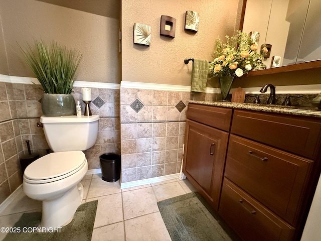 3920 Red Talon Dr, Anchorage, AK 99507 - bathroom with tile walls, vanity, wainscoting, and a textured wall