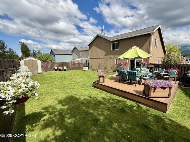 3920 Red Talon Dr, Anchorage, AK 99507 - rear view of house with a shed, a fenced backyard, a wooden deck, and outdoor dining area
