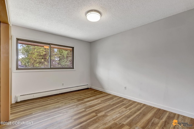 3223 Madison Way, Anchorage, AK 99508 - empty room with a baseboard heating unit, wood finished floors, and a textured ceiling