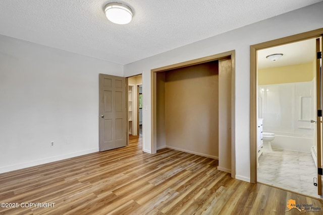 3223 Madison Way, Anchorage, AK 99508 - unfurnished bedroom with light wood finished floors, a textured ceiling, a closet, and ensuite bath
