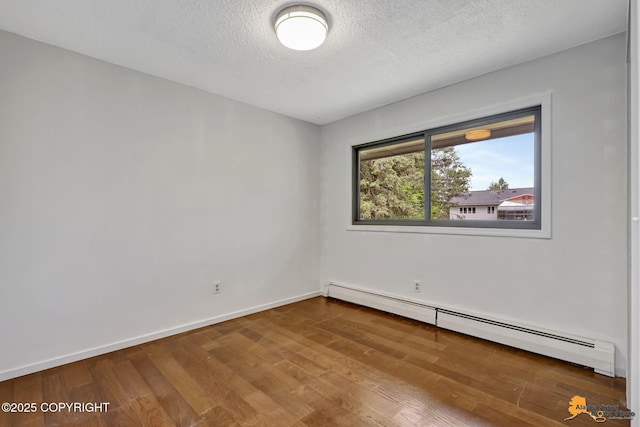 3223 Madison Way, Anchorage, AK 99508 - unfurnished room with a baseboard heating unit, wood finished floors, and a textured ceiling
