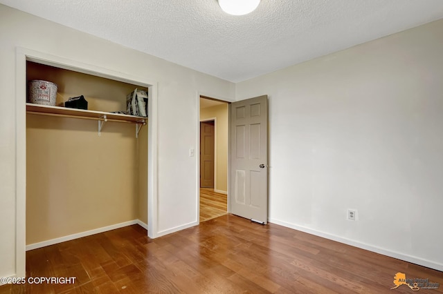 3223 Madison Way, Anchorage, AK 99508 - unfurnished bedroom with wood finished floors, a closet, and a textured ceiling