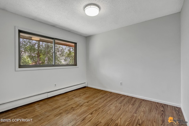3223 Madison Way, Anchorage, AK 99508 - unfurnished room featuring a baseboard radiator, a textured ceiling, and wood finished floors