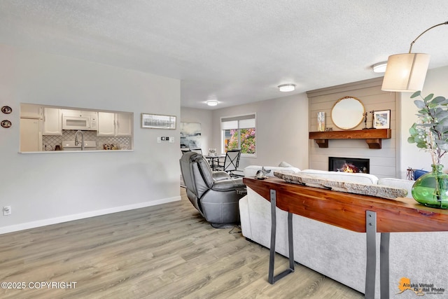 4800 Carousel Cir, Anchorage, AK 99502 - living area with a fireplace, light wood-style floors, and a textured ceiling