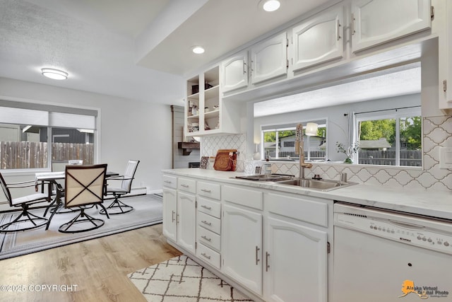 4800 Carousel Cir, Anchorage, AK 99502 - kitchen with white dishwasher, tasteful backsplash, white cabinets, light wood-type flooring, and light countertops