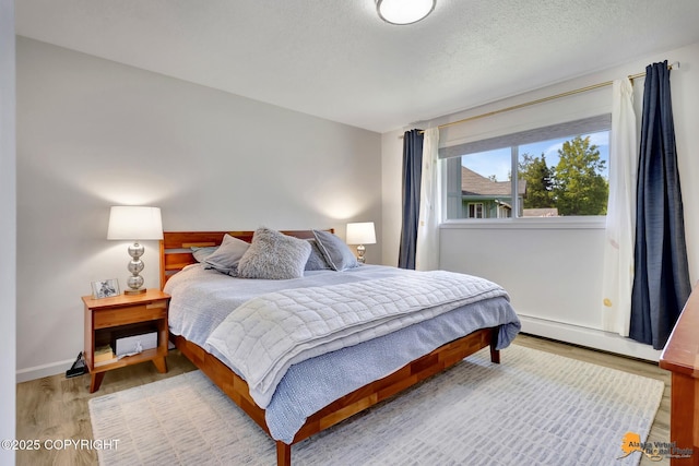 4800 Carousel Cir, Anchorage, AK 99502 - bedroom featuring wood finished floors, baseboard heating, and a textured ceiling