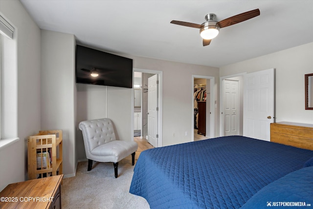 2943 Kingfisher Dr, Anchorage, AK 99502 - bedroom with a spacious closet, light carpet, connected bathroom, and a ceiling fan