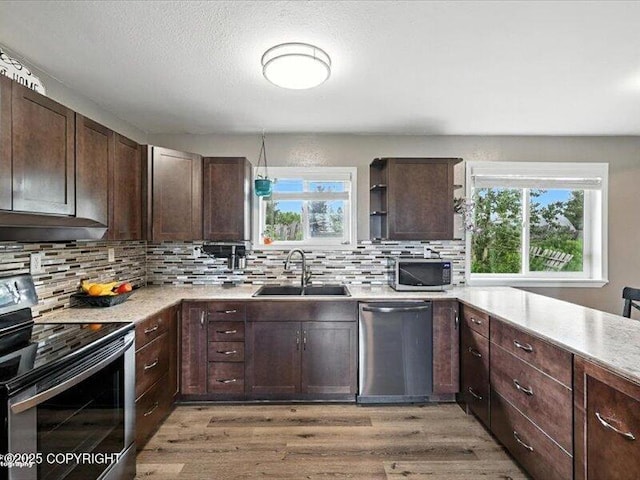 72155 Shannon Rd, Anchor Point, AK 99556 - kitchen featuring appliances with stainless steel finishes, light wood-type flooring, light countertops, and dark brown cabinetry