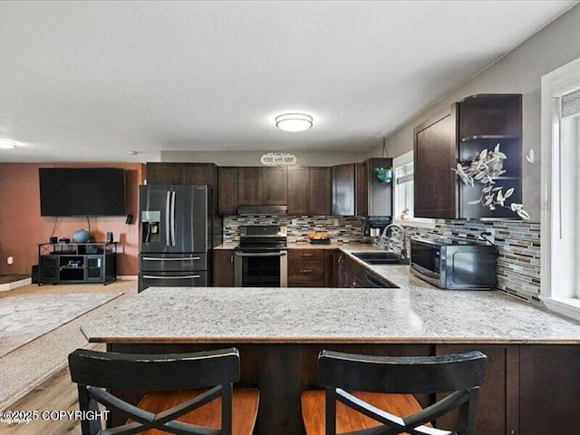 72155 Shannon Rd, Anchor Point, AK 99556 - kitchen with fridge with ice dispenser, range, stainless steel microwave, dark brown cabinetry, and a peninsula