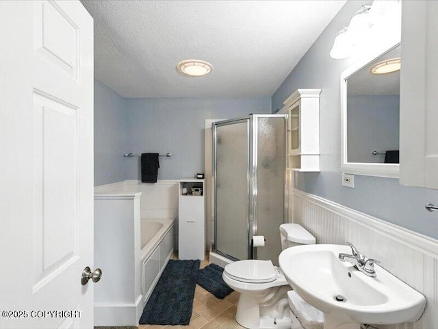 72155 Shannon Rd, Anchor Point, AK 99556 - bathroom with wainscoting, a garden tub, a stall shower, and a textured ceiling