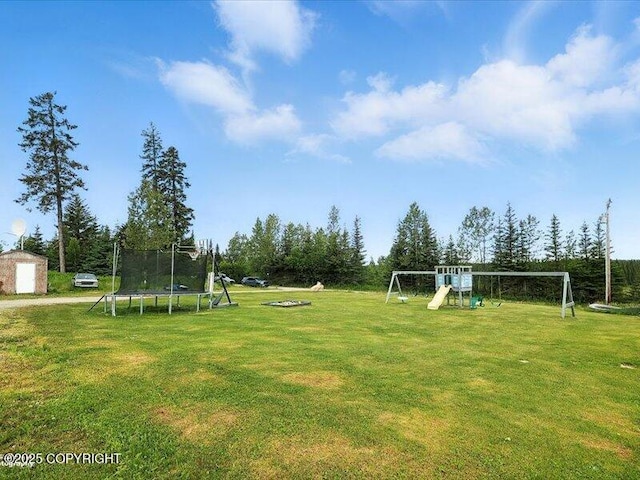 72155 Shannon Rd, Anchor Point, AK 99556 - view of grassy yard with a trampoline, a playground, and a storage shed