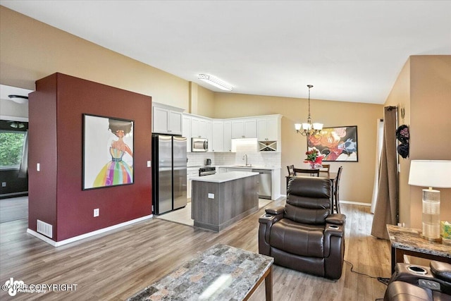 2608 Lauren Creek Loop # 4, Anchorage, AK 99507 - living area with vaulted ceiling, a chandelier, and light wood-type flooring