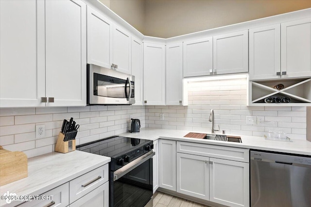 2608 Lauren Creek Loop # 4, Anchorage, AK 99507 - kitchen with appliances with stainless steel finishes, tasteful backsplash, white cabinetry, and light stone countertops