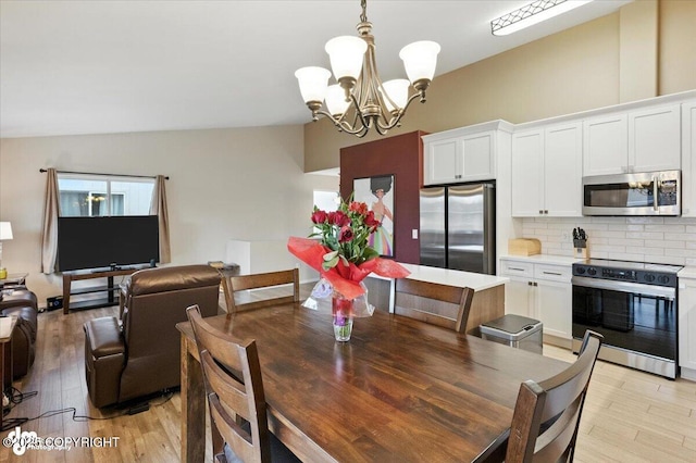 2608 Lauren Creek Loop # 4, Anchorage, AK 99507 - dining area with light wood-style floors, a chandelier, and vaulted ceiling