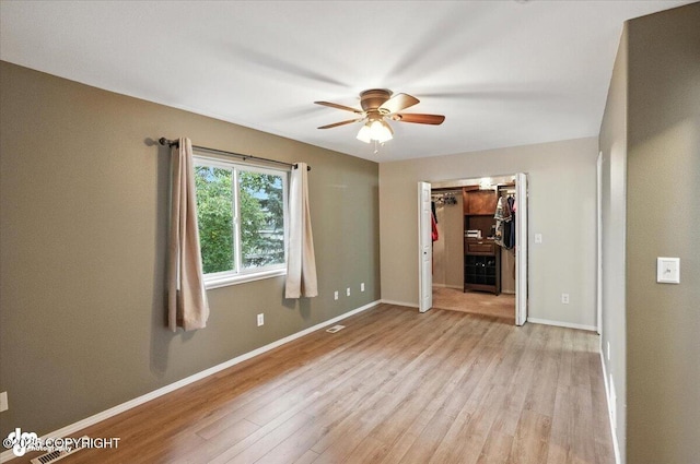 2608 Lauren Creek Loop # 4, Anchorage, AK 99507 - unfurnished bedroom with light wood-style flooring, a spacious closet, a closet, and ceiling fan