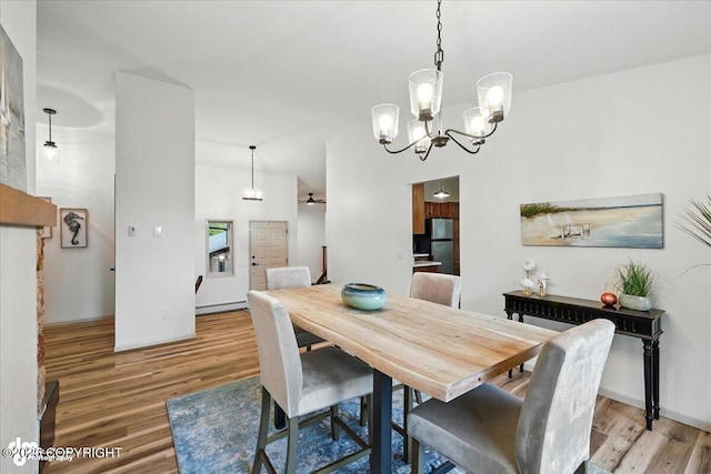 3291 N Edgewater Dr, Wasilla, AK 99623 - dining space with light wood-style flooring, a chandelier, and vaulted ceiling