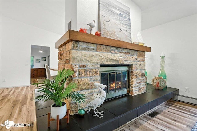 3291 N Edgewater Dr, Wasilla, AK 99623 - detailed view of wood finished floors, a stone fireplace, and baseboard heating