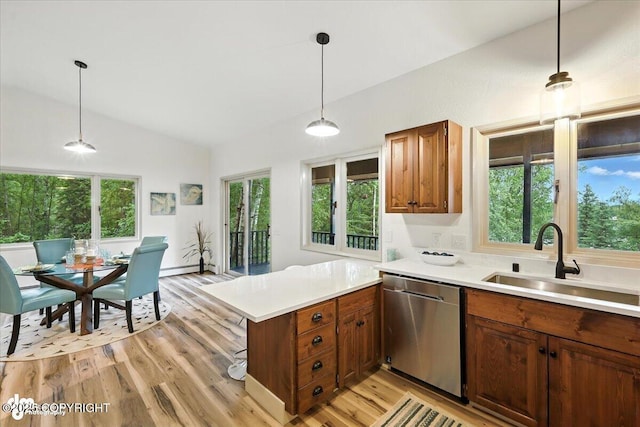 3291 N Edgewater Dr, Wasilla, AK 99623 - kitchen featuring stainless steel dishwasher, lofted ceiling, a peninsula, light countertops, and light wood-style floors