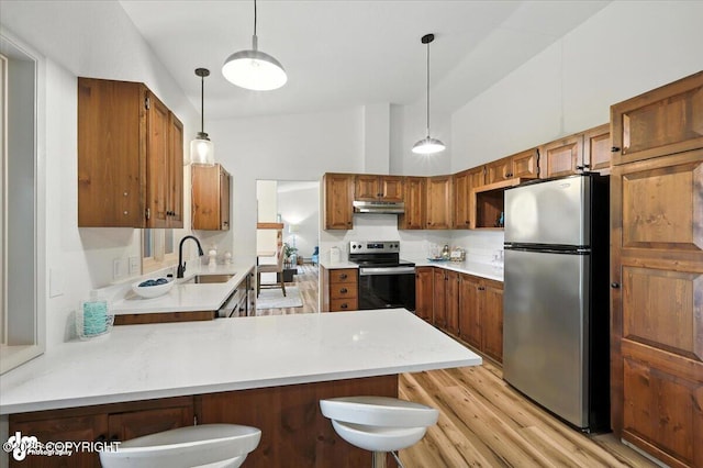 3291 N Edgewater Dr, Wasilla, AK 99623 - kitchen featuring appliances with stainless steel finishes, under cabinet range hood, light countertops, a peninsula, and brown cabinets