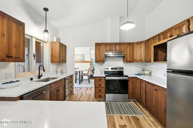 3291 N Edgewater Dr, Wasilla, AK 99623 - kitchen featuring appliances with stainless steel finishes, under cabinet range hood, light wood-style flooring, pendant lighting, and light countertops