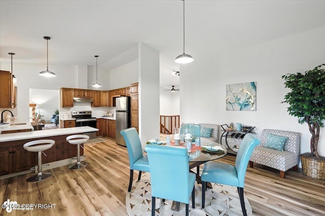 3291 N Edgewater Dr, Wasilla, AK 99623 - dining room with light wood-style floors, a towering ceiling, and a ceiling fan