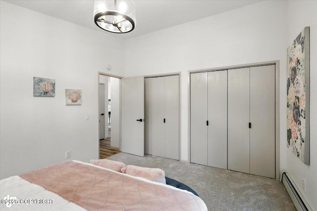 3291 N Edgewater Dr, Wasilla, AK 99623 - bedroom featuring baseboard heating, multiple closets, carpet flooring, and a chandelier
