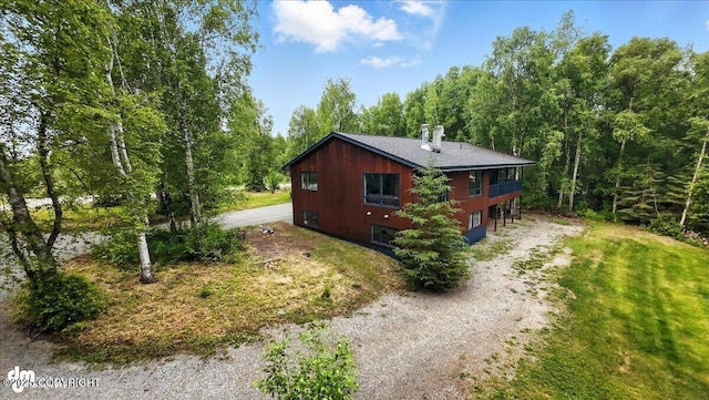3291 N Edgewater Dr, Wasilla, AK 99623 - view of property exterior with dirt driveway, a chimney, and a wooded view