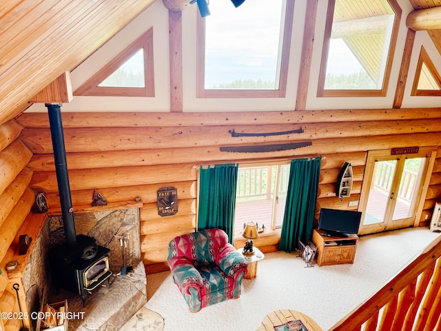 28180 Coastal Vista Cir, Anchor Point, AK 99556 - living room featuring high vaulted ceiling, rustic walls, a wood stove, healthy amount of natural light, and carpet flooring