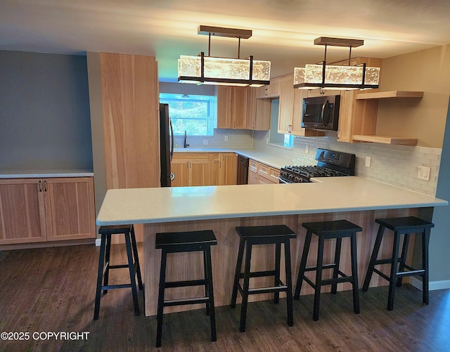 3043 Lakeview Dr, Kodiak, AK 99615 - kitchen featuring gas range oven, a peninsula, freestanding refrigerator, dark wood-style floors, and decorative backsplash