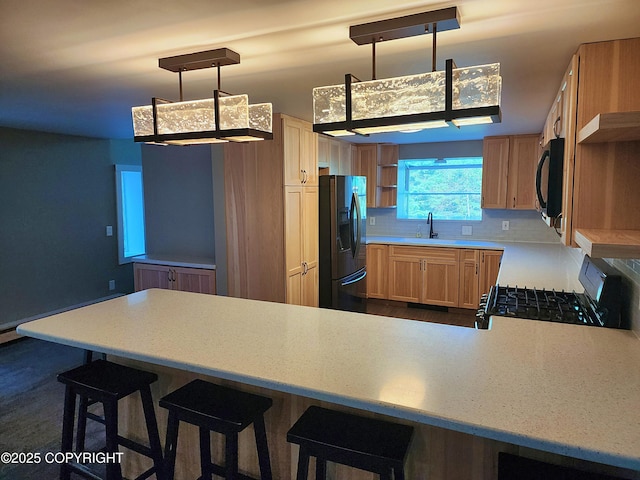 3043 Lakeview Dr, Kodiak, AK 99615 - kitchen with black appliances, light countertops, a peninsula, tasteful backsplash, and a breakfast bar area