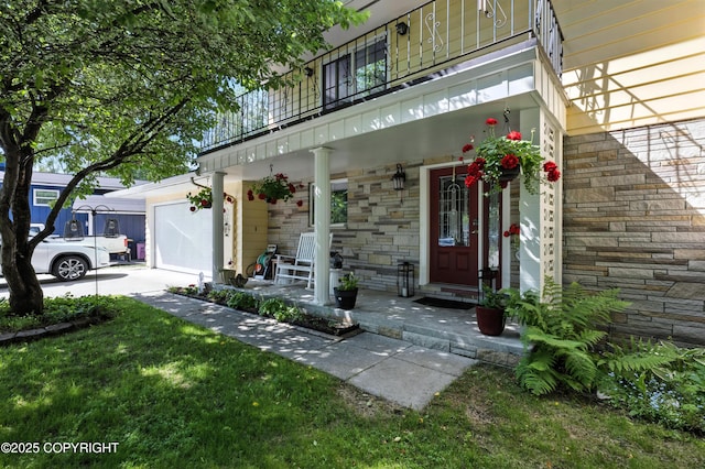 3002 Glacier St, Anchorage, AK 99508 - view of exterior entry featuring covered porch, stone siding, an attached garage, and a balcony