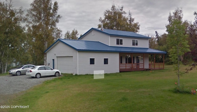 2534 S Saindon St, Wasilla, AK 99654 - rear view of property with an attached garage, a lawn, driveway, covered porch, and a metal roof