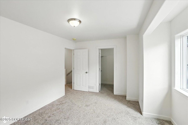 165 Rusty Allen Pl # 64, Anchorage, AK 99504 - unfurnished bedroom featuring carpet flooring, a spacious closet, and multiple windows