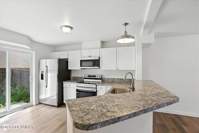 165 Rusty Allen Pl # 64, Anchorage, AK 99504 - kitchen with stainless steel appliances, light wood finished floors, a peninsula, white cabinets, and hanging light fixtures