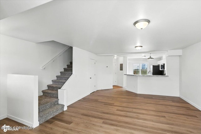 165 Rusty Allen Pl # 64, Anchorage, AK 99504 - unfurnished living room with wood finished floors and stairs