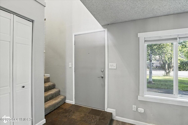 3298 Montpelier Ct Unit 12F, Anchorage, AK 99503 - entryway with dark stone finish flooring, a textured ceiling, and stairway