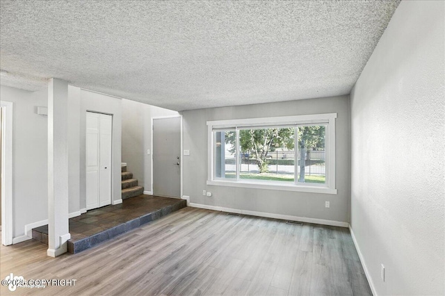 3298 Montpelier Ct Unit 12F, Anchorage, AK 99503 - foyer featuring wood finished floors, a textured ceiling, and stairs