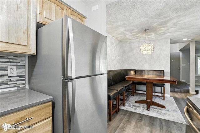 3298 Montpelier Ct Unit 12F, Anchorage, AK 99503 - kitchen featuring freestanding refrigerator, light brown cabinets, wood finished floors, decorative backsplash, and a textured ceiling